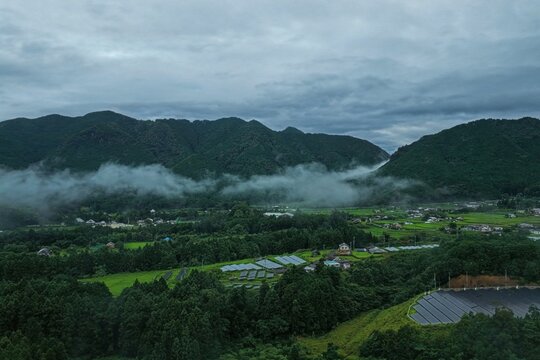 Aerial drone photo of sea of clouds over mountain valley with rice paddies in Mihama, Mie, Japan