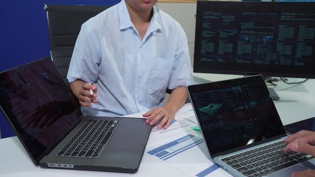 Male coder or developer working overtime using a computer display in problem solving at workplace.