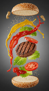 Exploded view of a delicious grilled beef burger with flying ingredients and sauces.