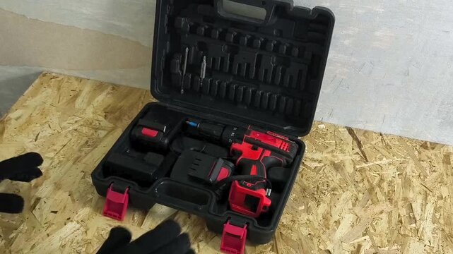Worker taking cordless screwdriver from tool case in workshop, auto repair, maintenance and power tools concept.