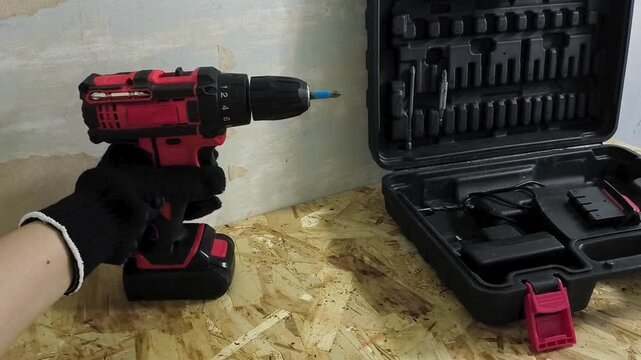Worker taking a cordless  screwdriver from the table, power tool, repair, construction and equipment maintenance concept.