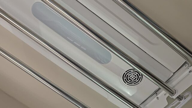 A video filmed of an electric clothes drying rack installed on the ceiling of an apartment balcony