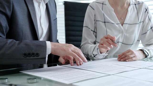 Business people discussing contract details, negotiating terms and conditions, reviewing legal documents, making financial decisions during a corporate meeting or consulting session