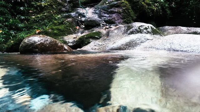 Clear Rainforest River Pool in Ecuador with Smooth Boulders, Green Jungle Banks, Freshwater Rapids and Remote Tropical Nature Scene
