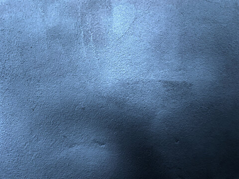 Dark blue abstract textured background with rustic cement grain and soft lighting.