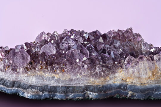 Amethyst crystal cluster on a light background showing natural formations and colors during daytime