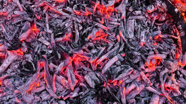 Glowing embers and hot charcoal texture close up.