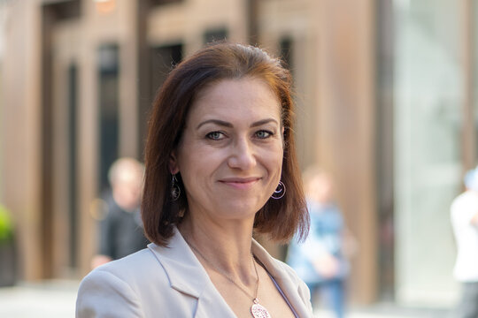 Confident middle aged woman smiling gently in an urban street portrait