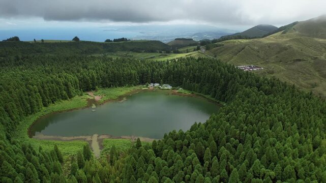 Aerial drone view of Lagoa do Canario, a volcanic crater lake surrounded by lush forest in the Sete Cidades area of Sao Miguel, Azores, Portugal