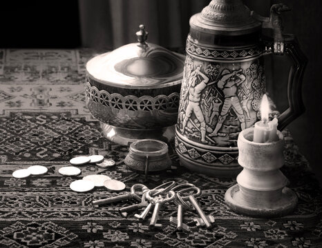 Still life with candle, keys and coins