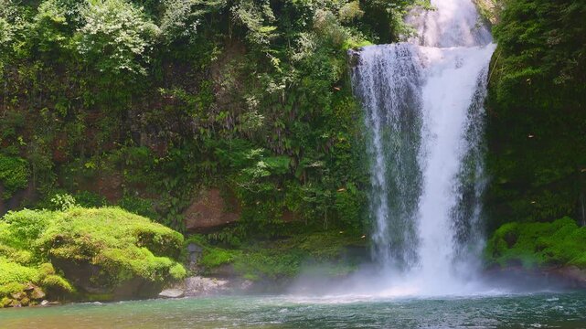 【スローモーション】苔むした岩場と澄んだエメラルドグリーンの滝壺へ注ぐ慈恩の滝
