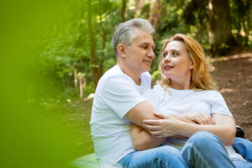 Fototapeta premium Mature Couple Embracing Face to Face at a Picnic