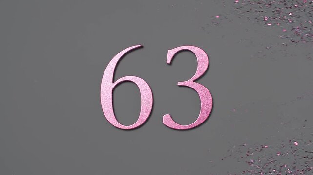 Pink Glitter Blows Away and Reveals the Number 63 on Solid Background