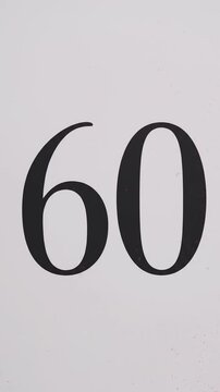 Pink Glitter Blows Away and Reveals the Number 60 on Solid Background