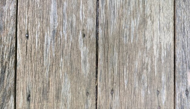 A rustic weathered wood plank background texture. Featuring varying light and dark brown tones with rich, detailed natural grain and a rough, distressed surface. Ideal for design backgrounds.