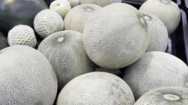 Fresh whole cantaloupe melons displayed at traditional market