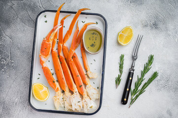Gourmet kamchatkan red crab legs with lemon and thyme arranged on white tray high quality seafood overhead shot © Mironov