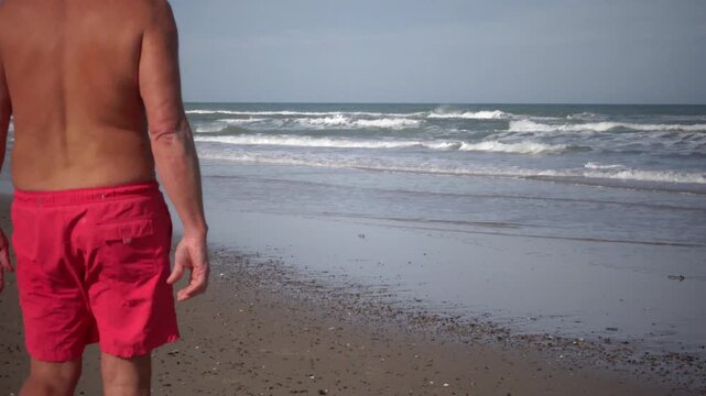 Hirtshals, Denmark A man does morning callisthenics and exercises on a sandy beach on the North Sea in summer. 