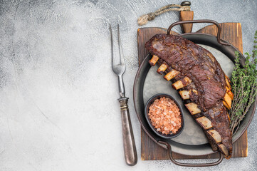 Roasted lamb ribs slab bone in with caramelized surface on rustic dark background gourmet barbecue food © Mironov