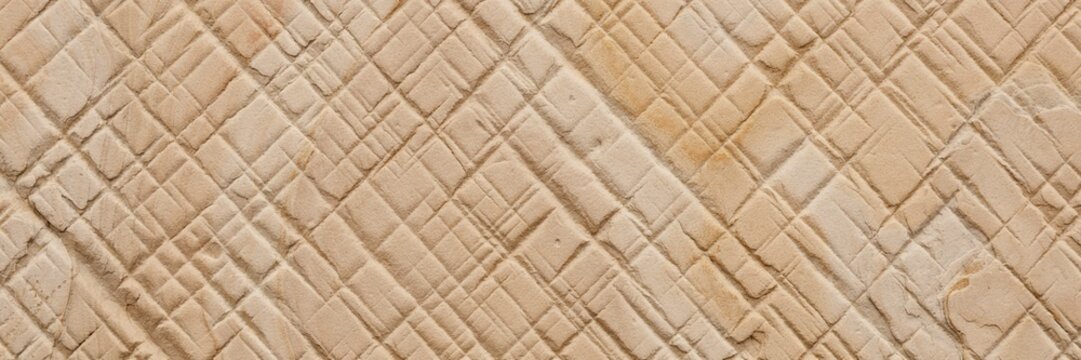 Textured sandstone surface with carved grid pattern, natural beige stone wall with geometric chiseled lines, organic rock background for architectural design and construction projects