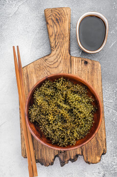 Edible sea grapes green caviar sea caviar in bowl on wooden board with soy sauce Asian marine superfood flat lay