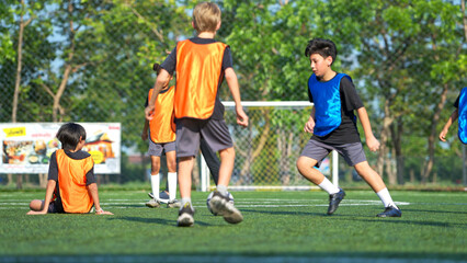 Fototapeta premium Football coach training international school students on the field,