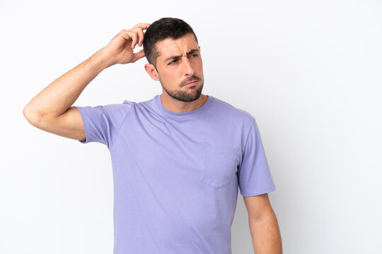 Young handsome caucasian man isolated on white background having doubts while scratching head