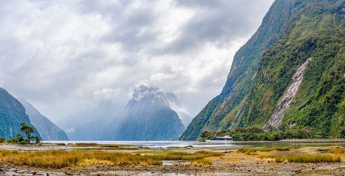 Milford Sound mit Mitre Peak im Nebel: Ausflugsboot durchquert den Fjord bei Ebbe, Fiordland-Nationalpark, Neuseeland