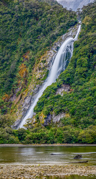 Wasserfall st&uuml;rzt durch &uuml;ppigen Regenwald in den Milford Sound, vermutlich Bowen Falls, Fiordland-Nationalpark, Neuseeland