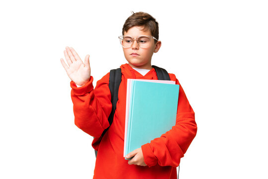 Little caucasian student kid over isolated chroma key background making stop gesture and disappointed