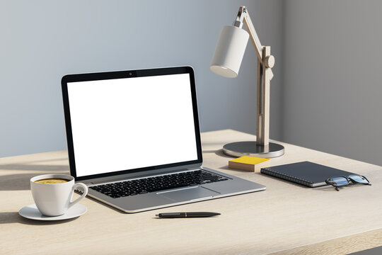 Blank laptop screen on a clean office desk with lamp, coffee, notebook, and copyspace for modern workspace branding design. 3D Rendering