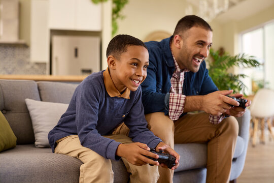 Father and son play video games and have fun at home