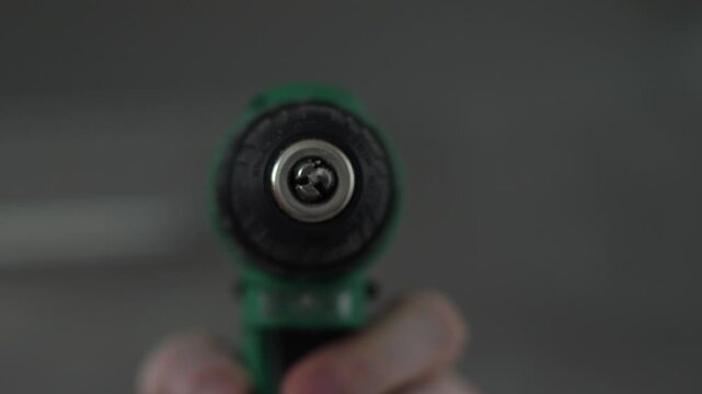 Close up front view of a cordless power drill chuck with an illuminated bright LED light. Professional electric tool pointed directly at the camera before starting renovation or construction work