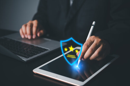 Businessman using tablet with blue premium security shield hologram and three star rating quality assurance
