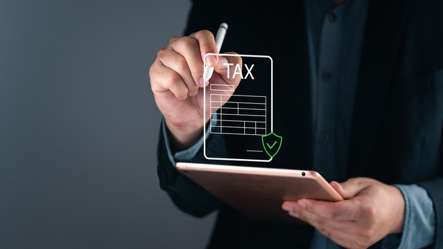 Businessman using tablet with digital tax form and green secure shield hologram