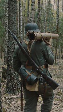 Wehrmacht Soldier Walking Through Pine Forest Wearing Shelter Cloak During WWII Eastern Campaign