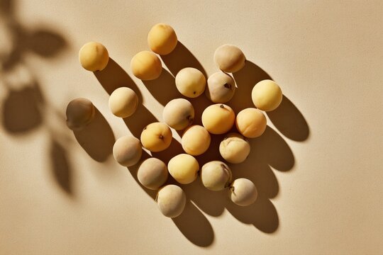 Ultra realistic longkong fruits, neat clusters, smooth beige-yellow skin, top-down flat lay, wide editorial composition, solid monochrome warm beige background slightly desaturated, fruits 