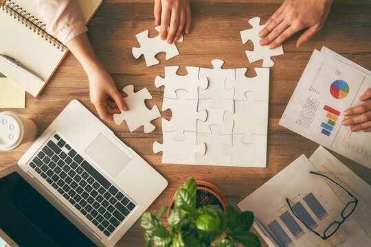 Collaborative team working on puzzle pieces for business strategy and financial planning concept with business