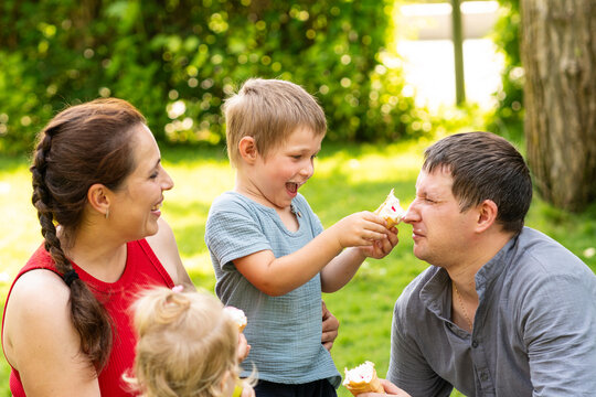 Playful Boy Teasing Father with Ice Cream Cone