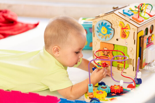 Baby Boy Explores Wooden Activity Cube During Tummy Time