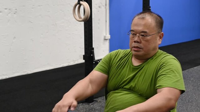 Seated rower exercise for overweight man indoor gym rowing workout fitness for overweight man seated rowing workout for overweight man indoor gym focused