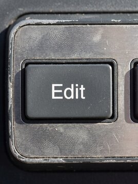 Generative AI, Close-up of a worn physical "Edit" button on a metal control panel