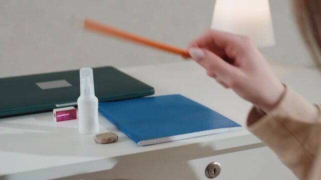 Caucasian woman hands organizing desk supplies, closeup shots of arranging pencils, notebook and sanitizer bottle careful motions opening drawer and reaching into bag, tidy prep for study session
