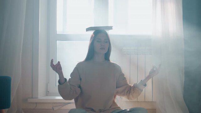 Young woman balancing book on head, student practicing breathwork and grammar focus in sunlit living room crosslegged on rug, soft curtain and window light, calm posture and study routine, tutorstyle