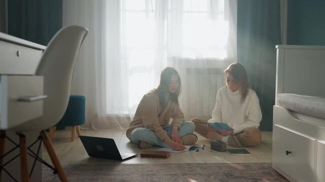 White tutor and learner on carpet, soft morning light, laptop and notebooks spread, grammar worksheet review, patient instruction, encouraging smiles, relaxed home study atmosphere, casual clothing,