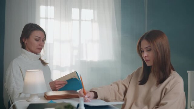 Home tutor and student at table, quiet tutoring session with grammar workbook and blue folder, lamp casting warm light, pen tracing sentences, tutor explaining corrections, student writing notes, soft