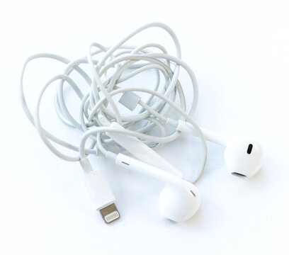 Tangled White Earphones With Cable on White Background
