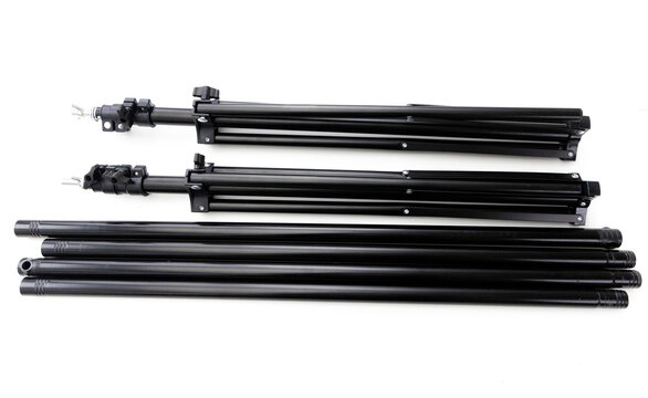 Black photography light stands and support poles on white background