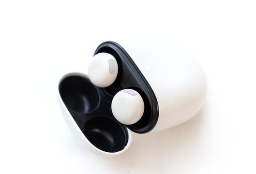 Wireless earbuds in a charging case on a white background