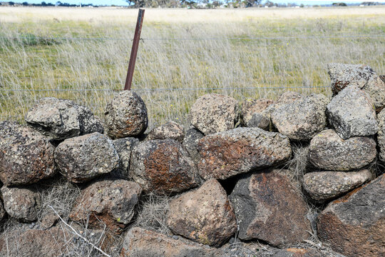 historical dry stone wall and farmland in western victoria